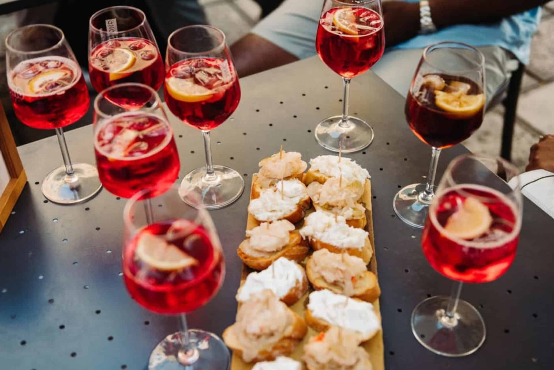 Verres de spritz et plateau de cicchetti au baccalà mantecato sur une table en terrasse à Venise Verres de spritz et plateau de cicchetti au baccalà mantecato sur une table en terrasse à Venise