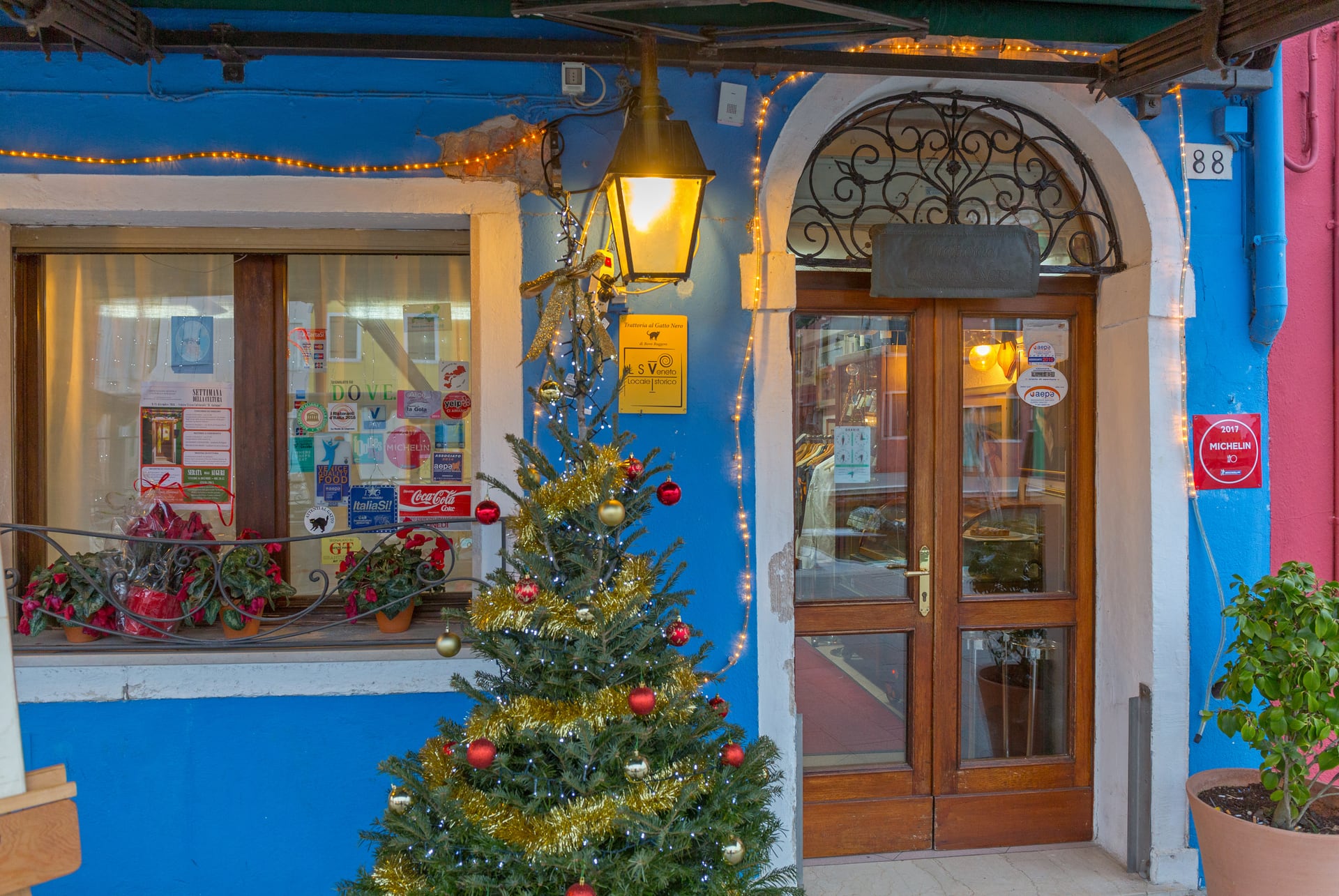 Façade bleue et porte d’entrée de la Trattoria al Gatto Nero, au numéro 88 sur l’île de Burano Façade bleue et porte d’entrée de la Trattoria al Gatto Nero, au numéro 88 sur l’île de Burano